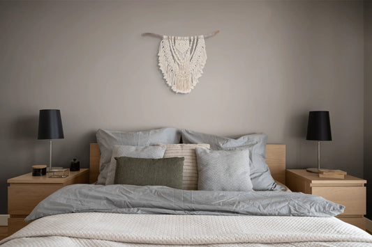 Grande tenture en macramé accrochée au mur au-dessus de la tête d'un lit