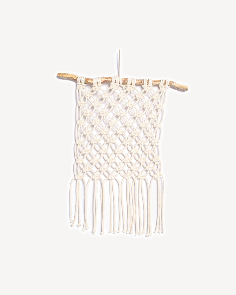 Tenture murale fleur de vie en macramé écru suspendue à une branche de bois naturel, création artisanale faite main.