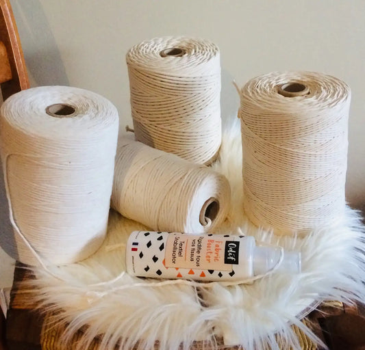 Quatre bobines de cordes pour le macramé sur un petit tapis de fourrure