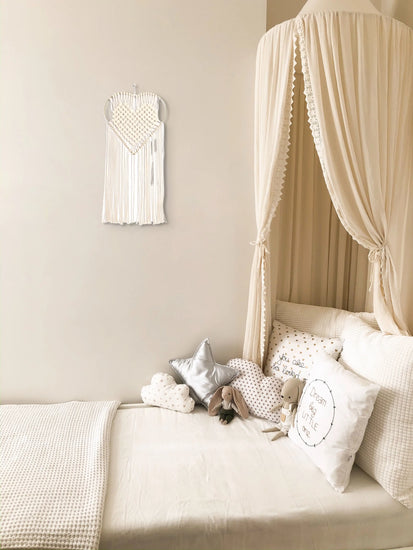 Tenture macramé Amour accrochée au mur d'une chambre de fille