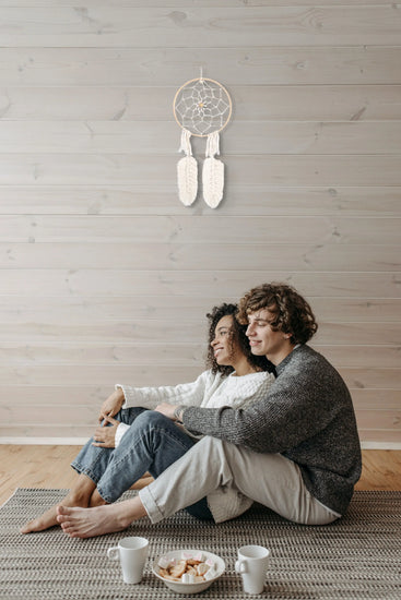 Attrape-rêves suspendu au mur sur des boiseries au-dessus d'un couple