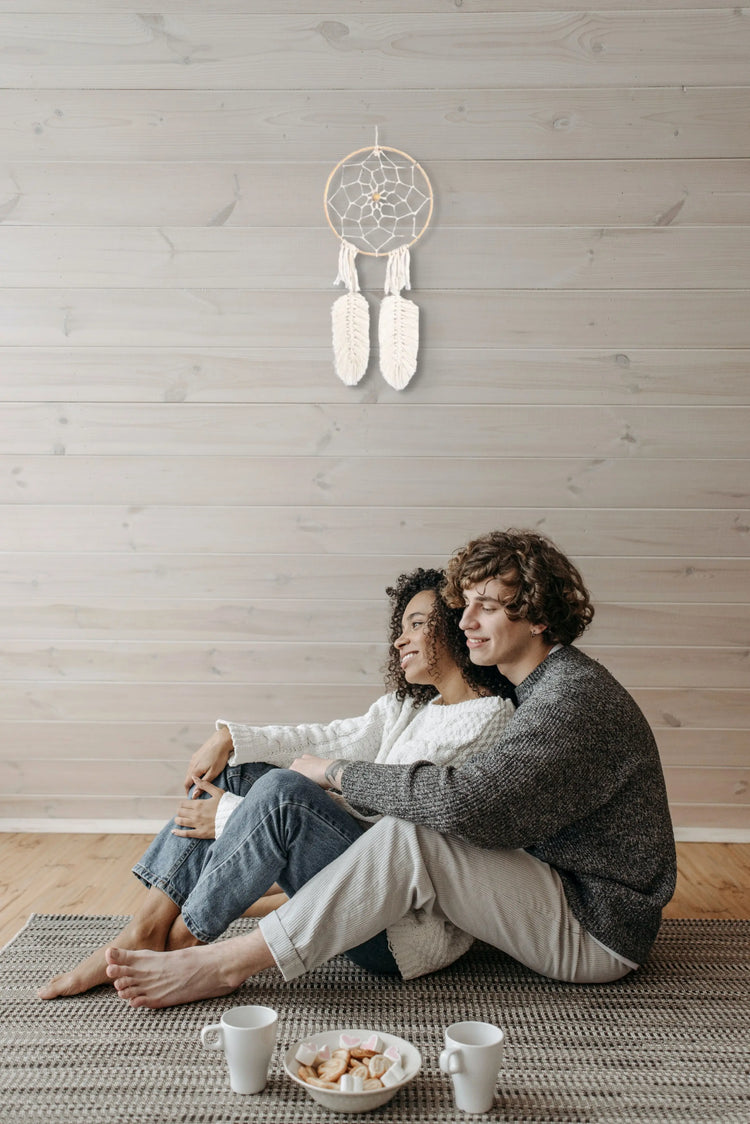 Attrape-rêves suspendu au mur sur des boiseries au-dessus d'un couple