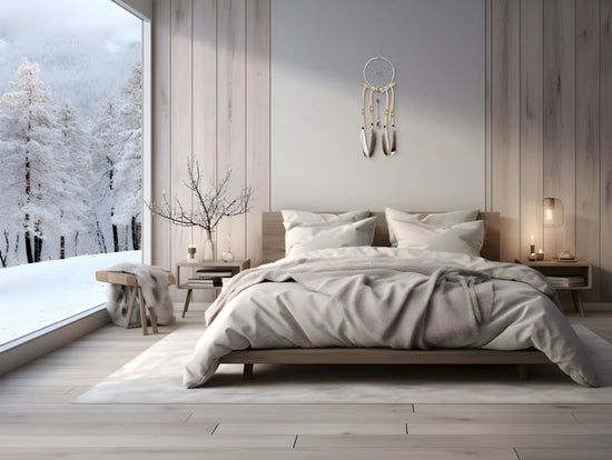 Attrape rêves suspendu au-dessus d'une tête de lit avec couette et décors extérieur enneigé