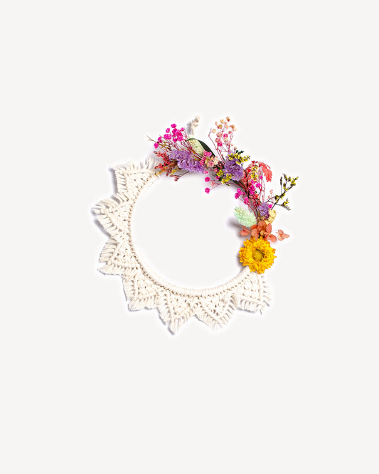 Couronne murale en macramé avec fleurs séchées colorées sur anneau en bois.