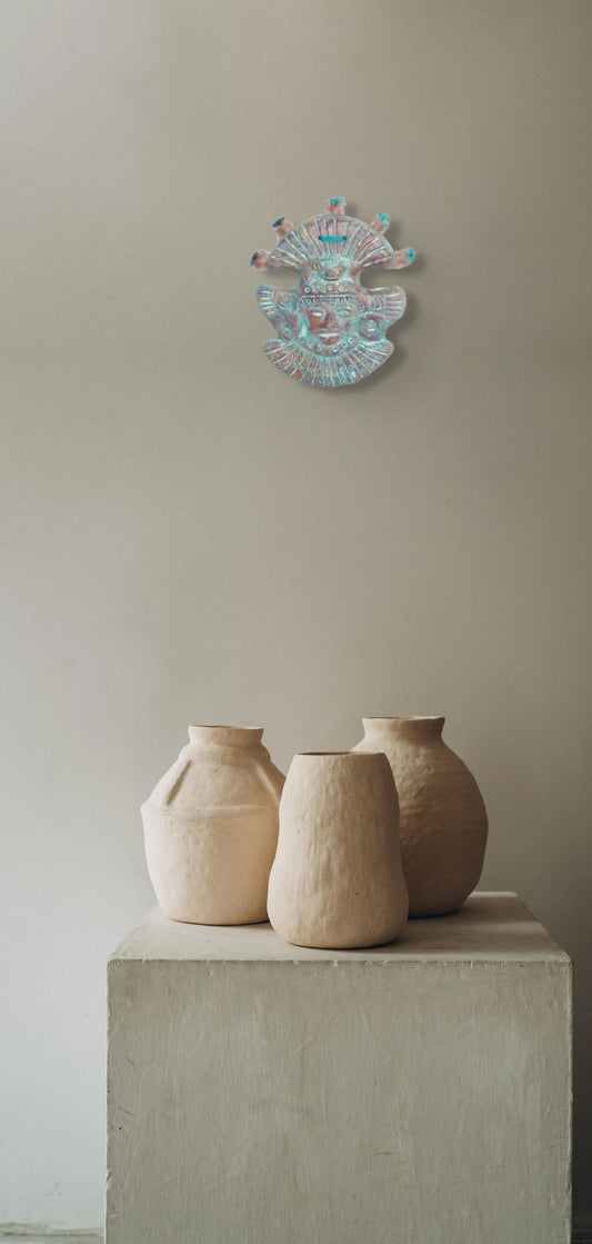 Création de style 'masque mexicain' en terre cuite suspendue au-dessus de trois pots en terre cuite