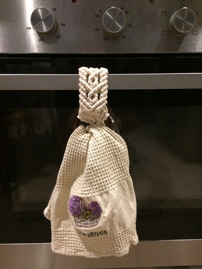 Porte-torchon en macramé mis en situation sur la poignée d'un four.