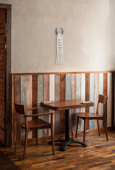 Décoration macramé et fer-à-cheval suspendue au-dessus d'une petite table en bois