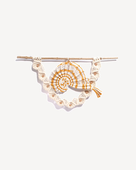 Tenture murale macramé avec motif nautile, corde safran et écrue, perles nacrées et bois naturel.