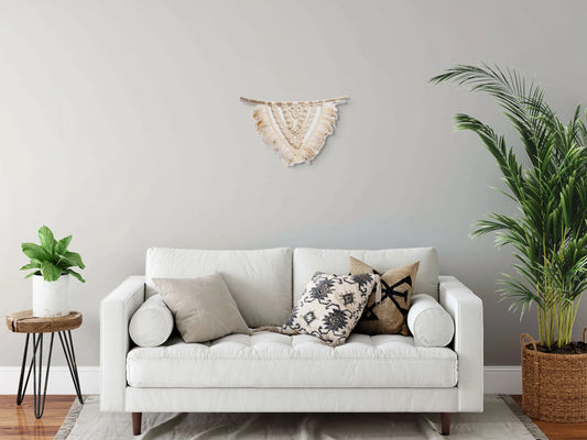 Tenture macramé accrochée dans un salon moderne.