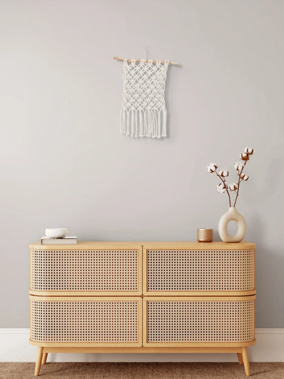 Tenture en macramé Fleur de vie accrochée au mur au-dessus d'un meuble en bois
