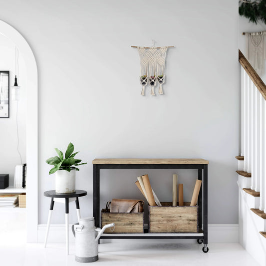 Suspension en macramé pour trois petits pots de plantes accrochée dans l'entrée d'une maison